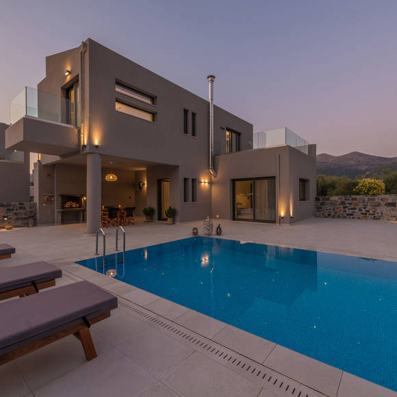 Private villa with illuminated pool at Avdou Collection by Trend Hotels during sunset in Crete