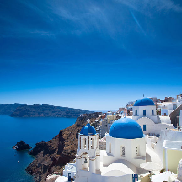 Iconic view of whitewashed houses and blue-domed churches overlooking the caldera in Santorini, Greece