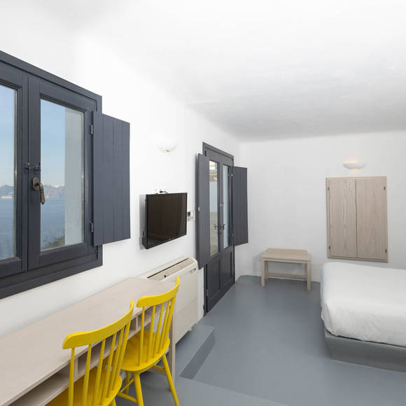 Minimalist sea view room at Grand Ambassador by Trend Hotels with modern decor and bright yellow chairs