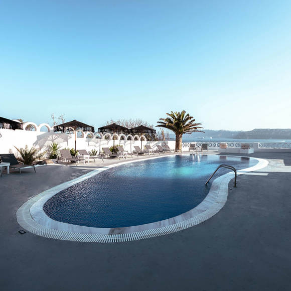 Serene poolside area at Santorini View Hotel by Trend Hotels with sea view and palm trees