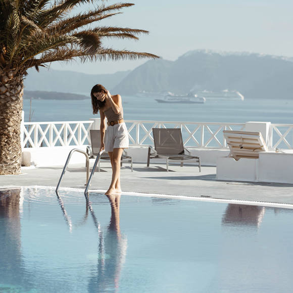 Guest enjoying the pool with caldera view at Santorini View Hotel by Trend Hotels in Fira