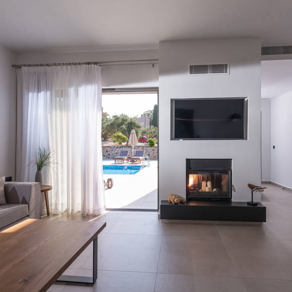 Elegant villa interior at Avdou Collection by Trend Hotels with fireplace and pool view in Crete