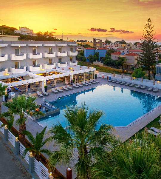 Aerial view of Dore Hotel by Trend Hotels in Chania with large outdoor pool and sunset backdrop