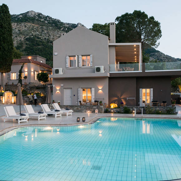 Evening view of the illuminated pool and villas at Avdou Collection by Trend Hotels in Crete