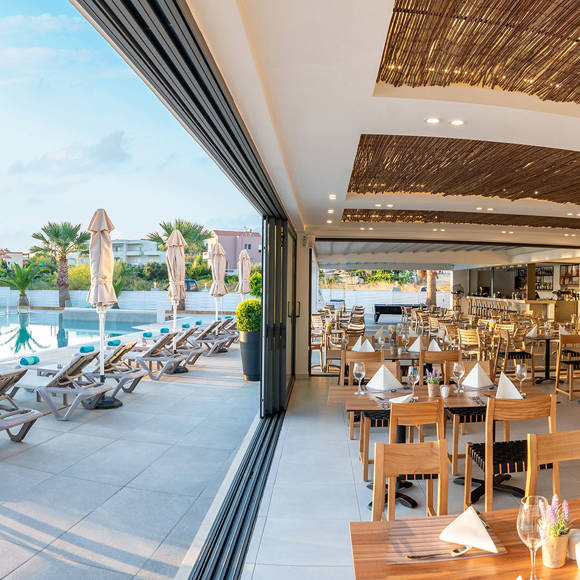 Poolside restaurant and dining area at Dore Hotel by Trend Hotels in Chania with bright summer ambiance