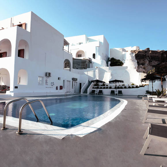 Outdoor swimming pool area at Santorini View Hotel by Trend Hotels with Cycladic white architecture